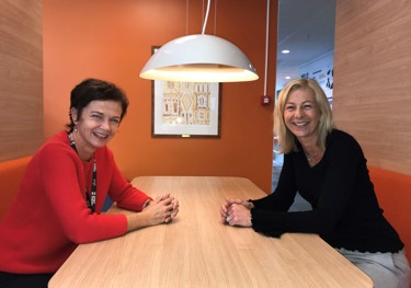 Two smiling women at a table