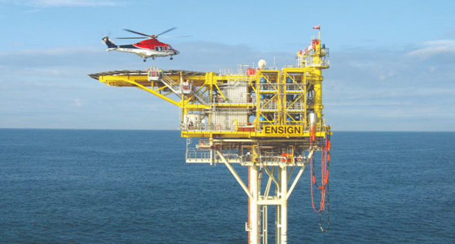 A helicopter is landing on a platform at sea
